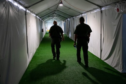 Customs and Border Protection agents walk down the hallway in U.S Customs and Border Protection
