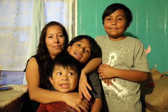 Amalia Mejia poses with her three children for a portrait in the trailer where she lived with her in-laws' family and two other adults after Hurricane Irma . The house they previously rented was severed by a falling tree during the hurricane, and irreparably damaged. Another Mejia lived in, owned by a former employer, allowed supervisors to come and go freely, including one who tried to force himself on her.