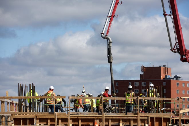 Construction crews pour concrete on one of the top levels of the new parking ramp at the Village on the River development in downtown Sioux Falls on Thursday, May 2.