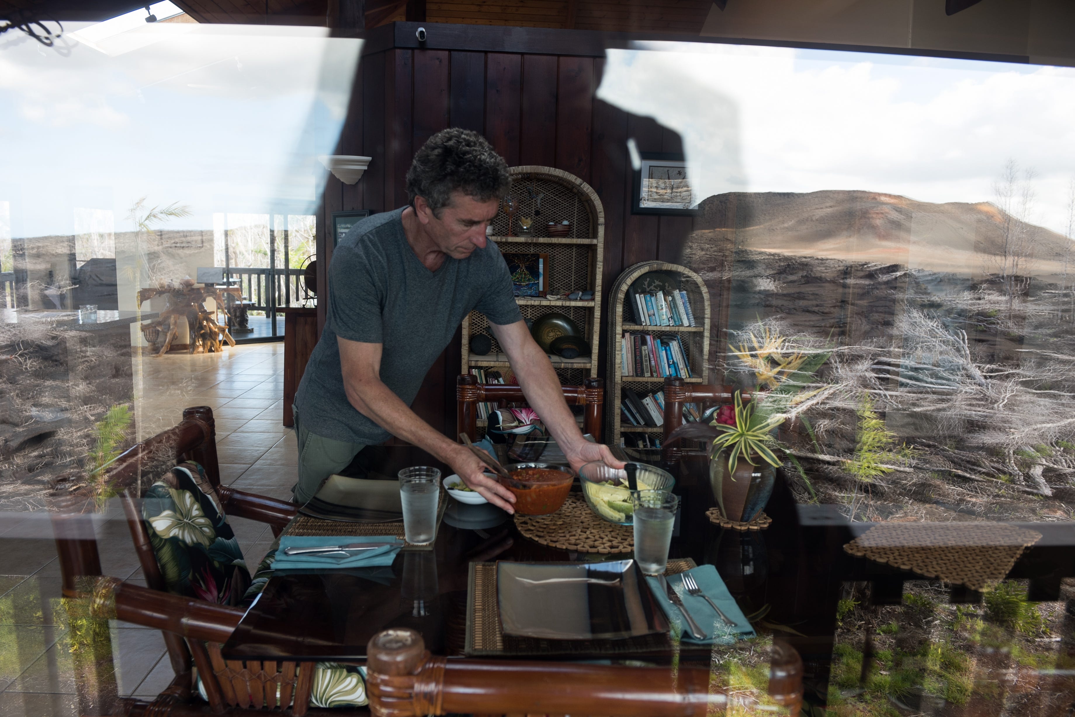 Mark Bishop prepares dinner at his home that he shares with his wife Jennifer in Leilani Estates. Their once private and secluded home, now looks out onto the lava field.