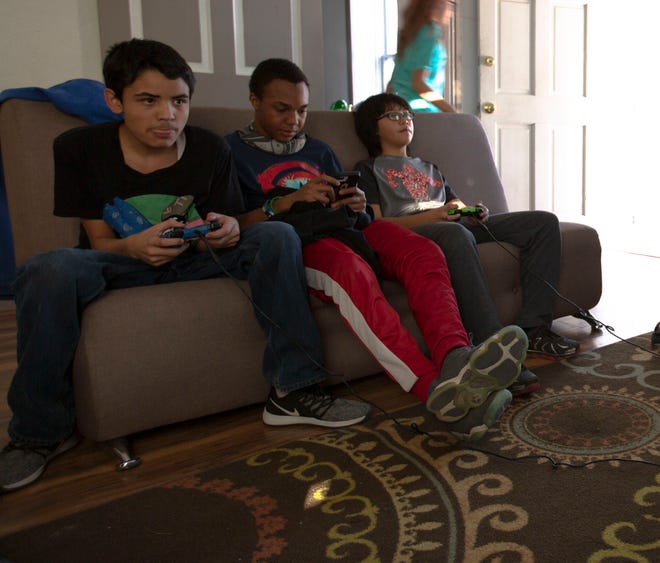 Joseph Contreras, 13, Jai Patterson, 14 , and Denzel Wright, 12, play video games during teen night at the Boys and Girls Club, Friday, May 3, 2019.