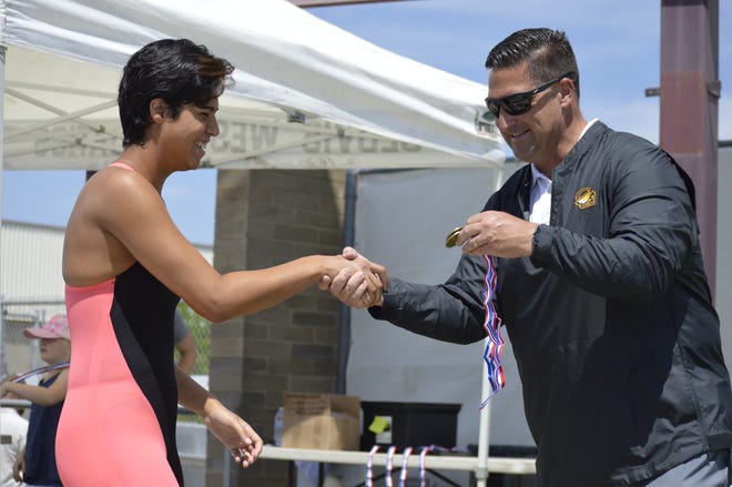 Golden West's Mackenzie Garza, left, is awarded the first-place medal after winning the girls 50-yard freestyle on Saturday at the Central Section swimming championships at Clovis West High School.