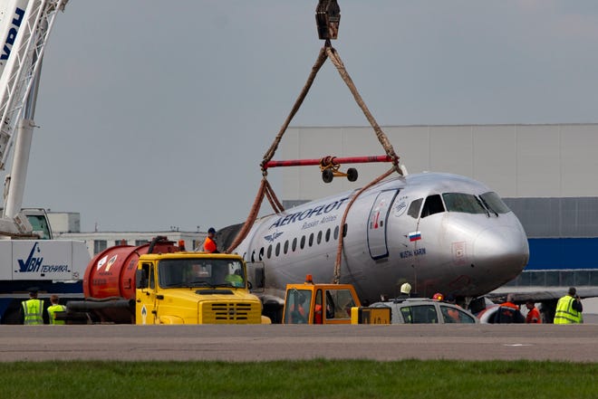 A crane lifts the damaged Sukhoi SSJ100 aircraft of Aeroflot Airlines in Sheremetyevo airport, outside Moscow, Russia, Monday, May 6, 2019.
