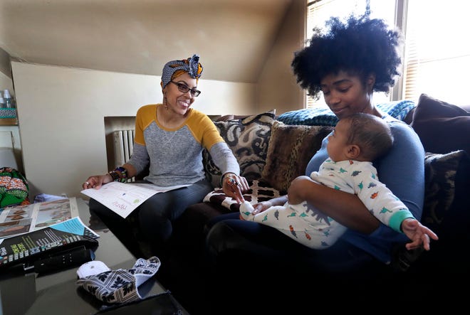 Vanessa Johnson, a doula and nurse, meets with client Natasha Lettner and her son for a post-delivery consultation.
