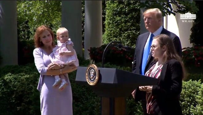 Ashley Evans (right) speaks at a National Day of Prayer event at the White House on Thursday, May 2, 2019 as President Donald Trump, Crystal Meyer and Evans' daughter, Olivia, look on.