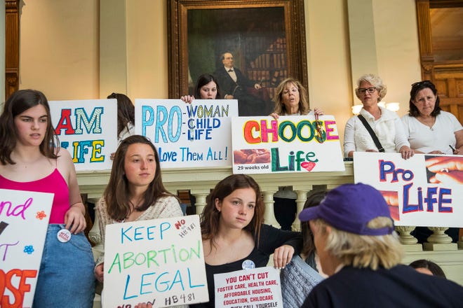 In this Friday, March 22, 2019, file photo, pro-abortion rights and anti-abortion demonstrators display their signs in the lobby of the Georgia State Capitol building.