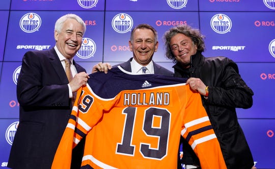 Ken Holland, in the center, is billed as the new Oilers Executive Director by Vice President Bob Nicholson, left, and owner Daryl Katz.