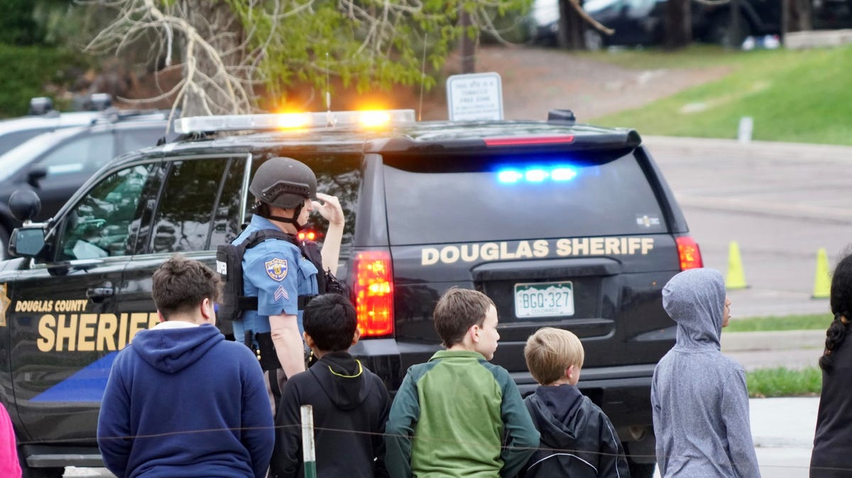 Police and school administrators load students onto school buses following a shooting in Highlands Ranch, Colorado.