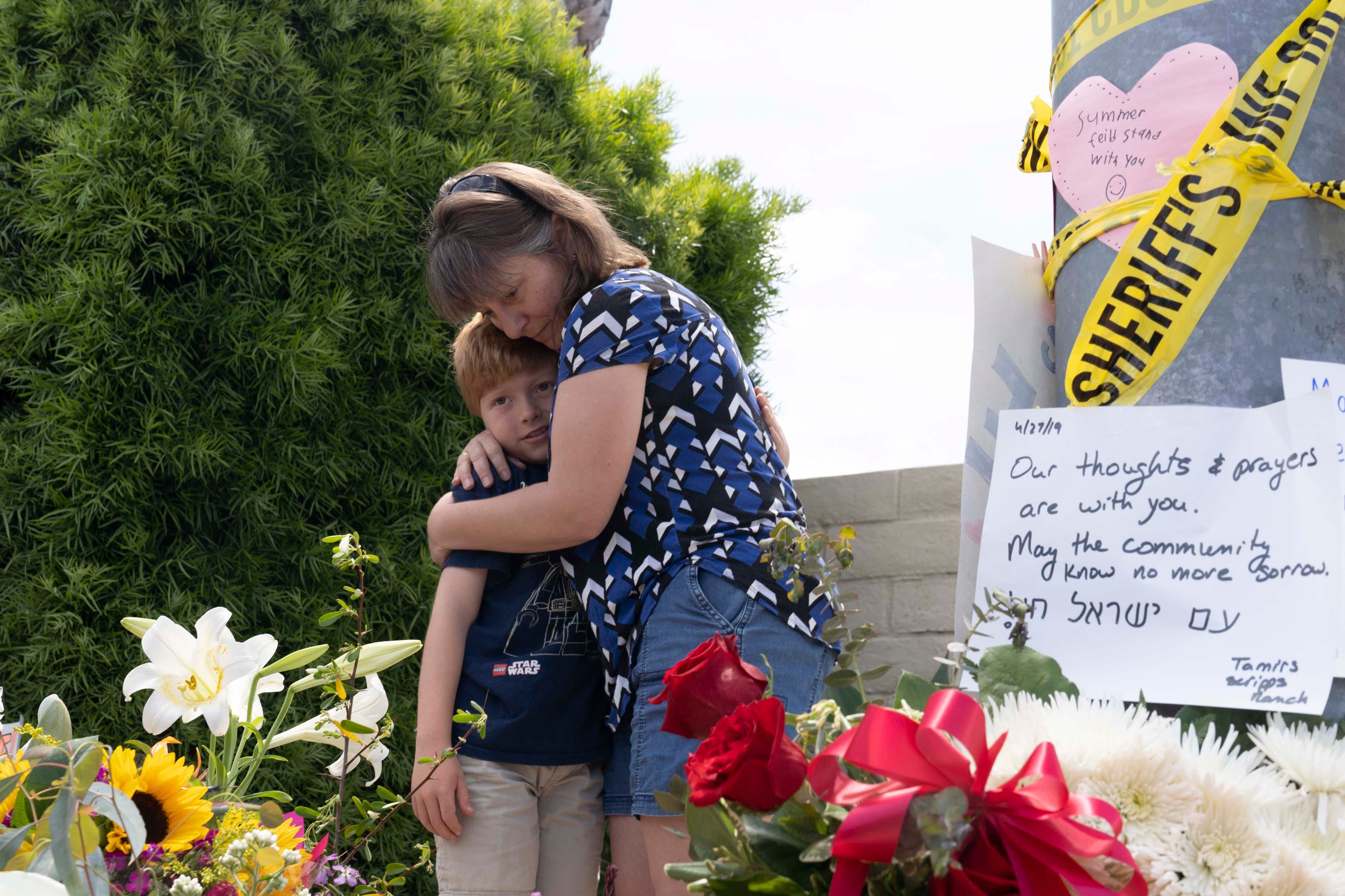 Heather Fay and her son Marshall pay their respects at the memorial site near the Chabad of Poway synagogue.