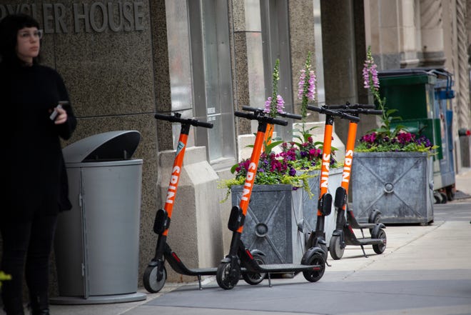 A group of Spin scooters sit outside of Chrysler House on Griswold Street in Detroit Wednesday, May 8, 2019.