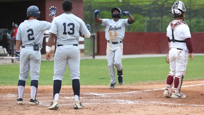 In this file photo, Dezmond Chumley crosses home plate as teammates Wesley Reyes (2) and Jaylyn Williams (13) wait to congratulate him.