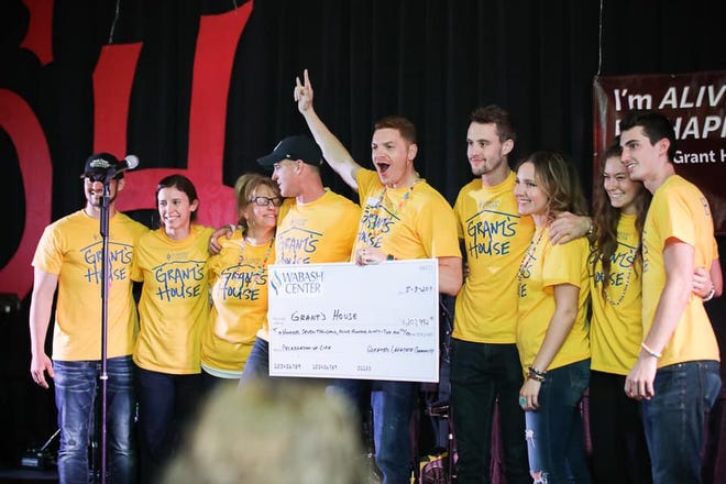 The family of Grant House stands on stage with with a large check totaling the $208,000 raised Friday evening during the annual "I'm Happy and I'm Alive" fundraiser.