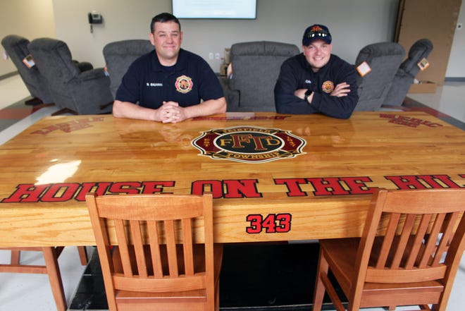 Fairfield Township firefighters Jacob Oakes, left, and Bryon Baumann sit at a table they built with Jason Agoston in 2011 that they brought over from the Tylersville Road station.