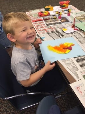 Dean Cramer, 2, of Hopewell shows off a painting he created during a Wee Read program at the Cumberland County Library in Bridgeton.