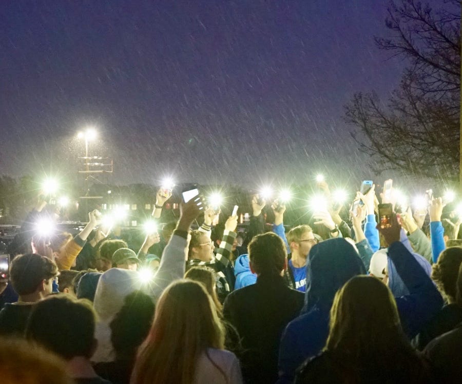 Standing in the pouring rain with their phone flashlights illuminated, students from the STEM School in Highlands Ranch, Colorado, hold a vigil outside a gun-control rally on Wednesday evening.