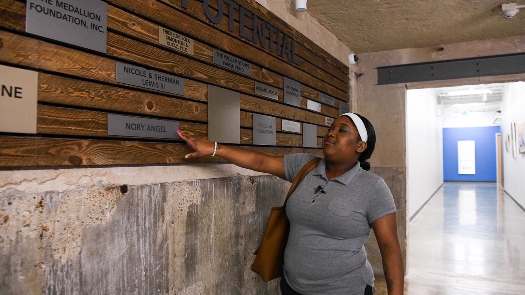 C'alra Bradley points out the name of her former mentor, Nory Angel, on a wall at SER Jobs Houston.