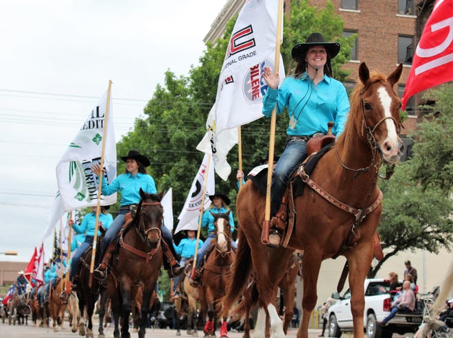 Cowgirls wave from horses at the start of Thursday evening's Western Heritage Classic parade in downtown Abilene. The annual May event continues Saturday at the Taylor County Expo Center.