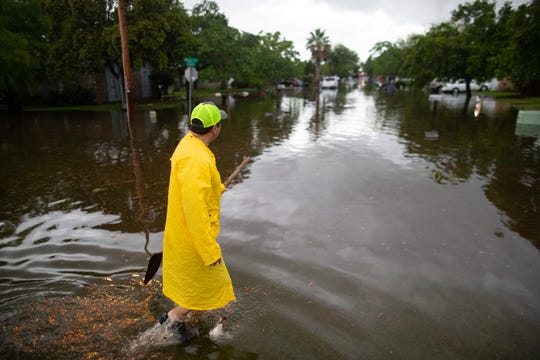 George Cabrera clears garbage from flood waters on Ursa Drive after heavy rains fell in the early morning on Friday, May 10, 2019.