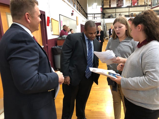 Kentucky Education Commissioner Wayne Lewis Jr., center, hears from South Middle School seventh-graders Alexia Barnett (second from right) and Alaya Culver (right) about their experience in the school’s Reality Day program during a tour led by Principal Ryan Reusch (left).
