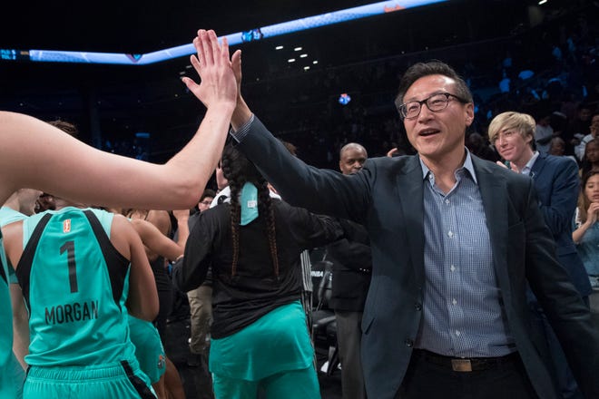 The New York Liberty's new owner, Joe Tsai, right, high-fives the Liberty players as they arrive at the bench at the end of a WNBA exhibition basketball game against China, Thursday, May 9, 2019, in New York. Tsai saw the team's exhibition game against the Chinese national team as a chance to grow relations between the two countries. (AP Photo/Mary Altaffer)