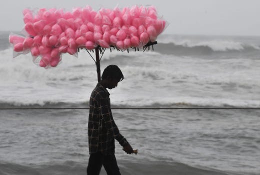 An Indian candy vendor walks along a closed beach in Puri in the eastern Indian state of Odisha on May 2, 2019, as cyclone Fani approaches the Indian coastline.