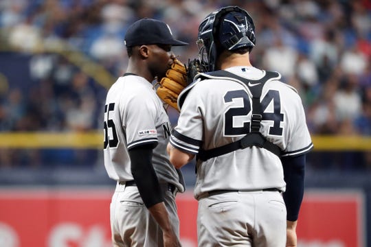 New York Yankees starting pitcher Domingo German (55) talks to receiver Gary Sanchez (24) in round five against the Tampa Bay Rays at Tropicana Field.