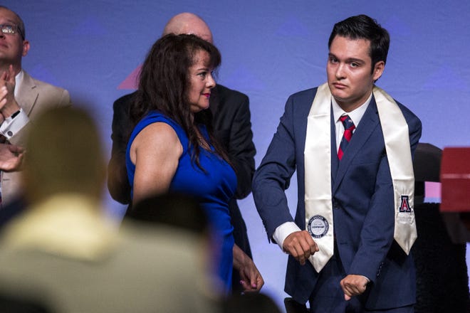 Hermelinda Bristol watches as her son, Jeffrey, 24, is recognized during University of Arizona's Eller College of Management convocation on Saturday, May 11, 2019, at McKale Memorial Center in Tucson, Ariz. Bristol, who was diagnosed with cavernous angioma as a child, has begun to learn how to walk with the help of an exoskeleton created as part of an engineering school design program.