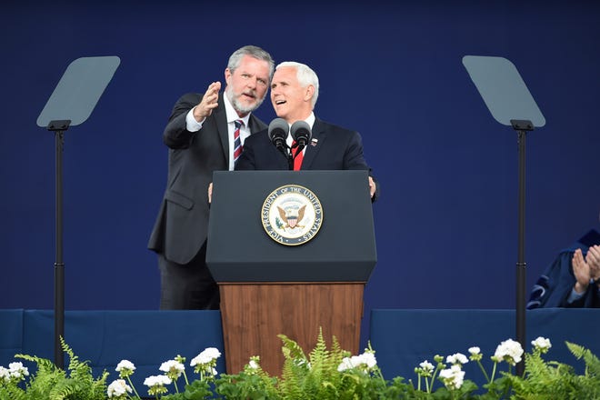 Liberty President Jerry Falwell Jr., left, speaks with Vice President Mike Pence at the Liberty University commencement ceremony in Lynchburg, Va., on Saturday, May 11, 2019.