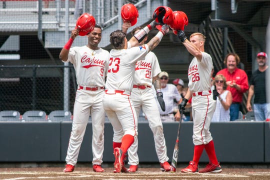 Todd Lott (9), Orynn Veillon (21) and Daniel Lahare (26) congratulate UL senior catcher Handsome Monica (23) after his three-run homer in Sunday's Senior Day 11-5 win over Georgia State.
