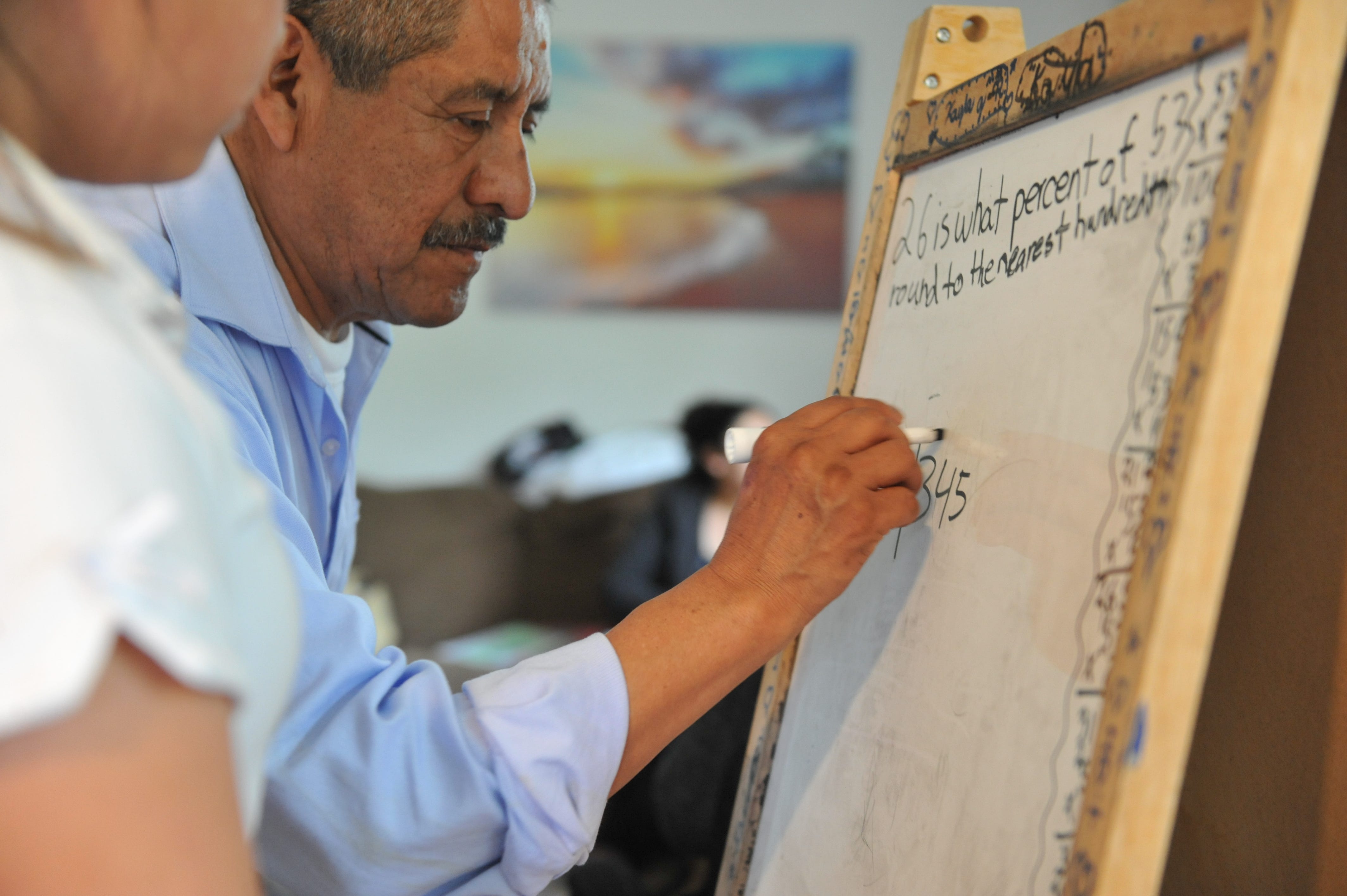 Adolfo González helps his granddaughter Kayla with her homework at his Salinas apartment.