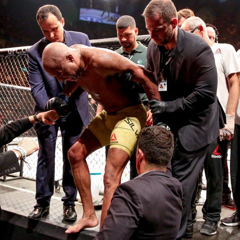 Anderson Silva is helped out of the ring after...