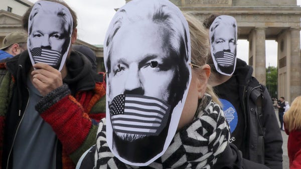 People wear paper masks to protest against a...