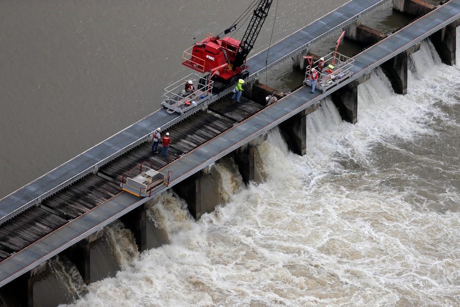 Workers open bays of the Bonnet Carre Spillway, to divert rising water from the Mississippi River to Lake Pontchartrain, upriver from New Orleans, in Norco, La., Friday, May 10, 2019. Torrential rains in Louisiana brought such a rapid rise on the river that the Army Corps of Engineers is opening the major spillway four days earlier than planned. Spokesman Ricky Boyett says the river rose six inches in 24 hours, with more rain expected through the weekend. (AP Photo/Gerald Herbert) ORG XMIT: LAGH103
