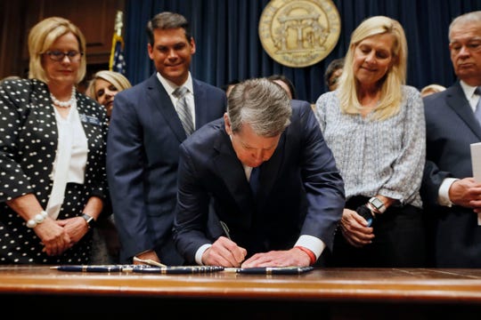 Georgia Republican Governor Brian Kemp signs a law banning abortions as soon as the fetal heart rate is detected in Atlanta on May 7, 2019.