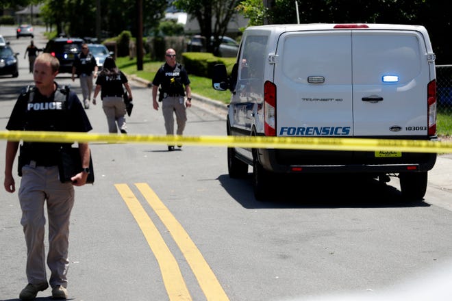 A forensics team and police officers work a crime scene in the surrounding areas of the intersection of Gibbs Drive and Alice Jackson Lane near Oakland Cemetery Tuesday, May 14, 2019. A victim was shot and killed. 