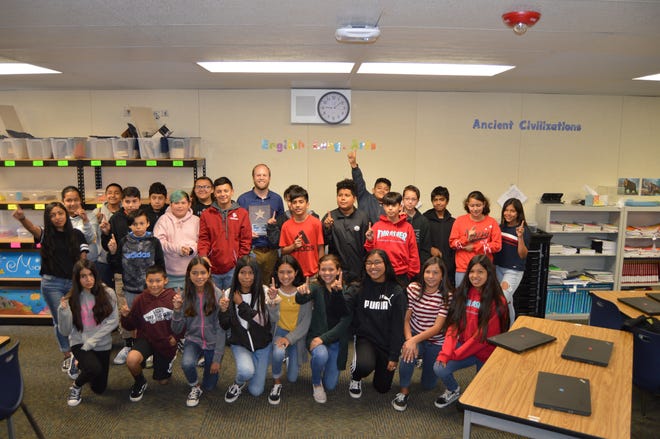 Isbell Middle School teacher Jan-Erik Sand stands with his students after being named Ventura County teacher of the year.