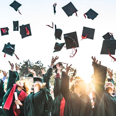 Large group of happy college students celebrating...
