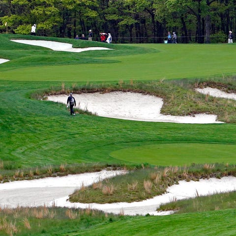 Golfers practice on the fifth hole of the Black...