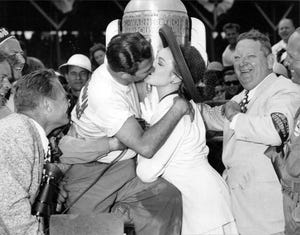 Bill Holland, winner of the 1949 Indianapolis 500, plants a kiss on actress Linda Darnell in victory lane.