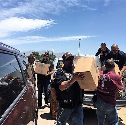 Volunteers unload non-perishable meals donated by...