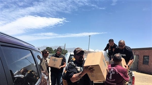 Volunteers unload non-perishable meals donated by...