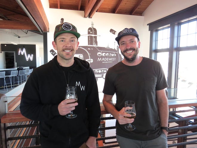 MadeWest Brewing Co. co-founders Mike Morrison, left, and Seth Gibson pose in the brewery's new, off-site taproom on the second floor of Beach House Fish on the Ventura Pier. Morrison, who serves as head brewer, and Gibson, the brewery's CEO, opened the original facility and taproom in 2016 with co-founder Scott Chenoweth, who created the mural seen in the background.
