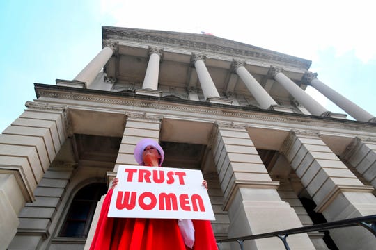 Activist Tamara Stevens with the Handmaids Coalition of Georgia stands outside the Georgia Capitol after Democratic presidential candidate Sen. Kirsten Gillibrand (D-NY) addressed an event to speak out against the recently passed 'heartbeat' bill on May 16, 2019 in Atlanta, Georgia. The bill, which bans abortions after a fetal heartbeat is detected around six weeks, was signed on May 15 by Alabama Governor Kay Ivey. Under the new measure, expected to come into effect in six months, performing an abortion is a crime that could land doctors in prison for up to 99 years.