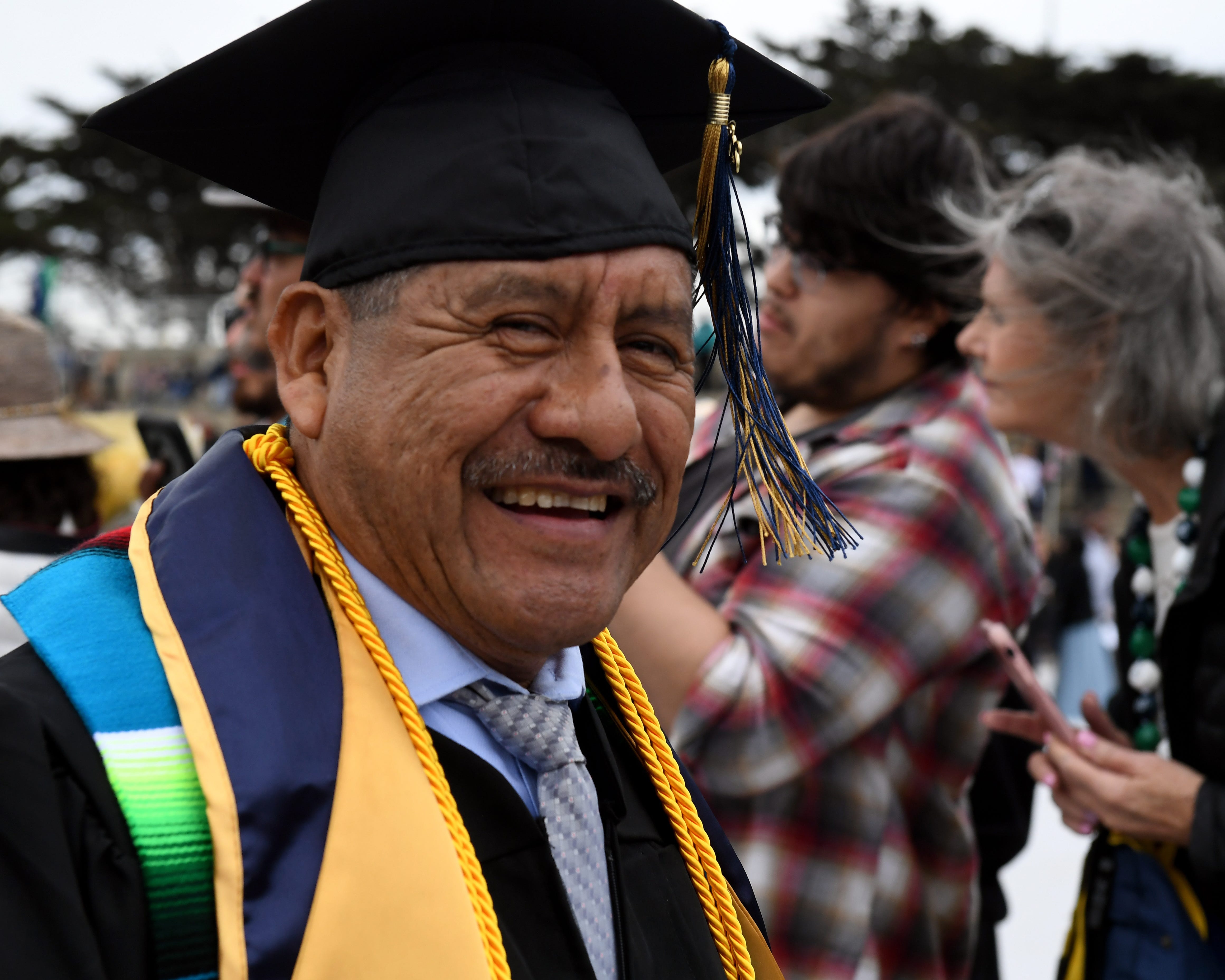 Adolfo González grins for the camera at CSUMB graduation from the College or Arts, Humanities and Social Sciences on Saturday, May 18, 2019.
