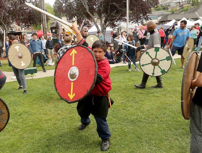 16 metų Devonas Brittelas, gyvenantis Tacomoje, 2019 m. gegužės 19 d., sekmadienį, 2019 m. gegužės 19 d., Poulsbo miesto centre, Vikingų kaime pristatytoje skydo sienelių demonstracijoje, praktikuoja kovos pozicijas.