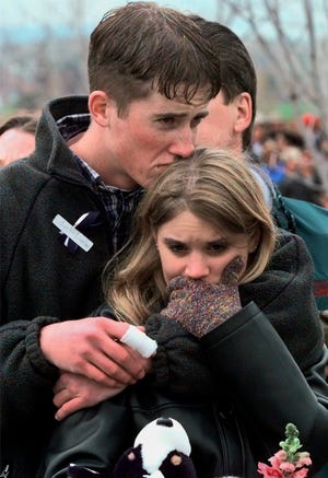 In this April 25, 1999 file photo, shooting victim Austin Eubanks hugs his girlfriend during a community wide memorial service in Littleton, Colo., for the victims of the shooting rampage at Columbine High School the previous week.