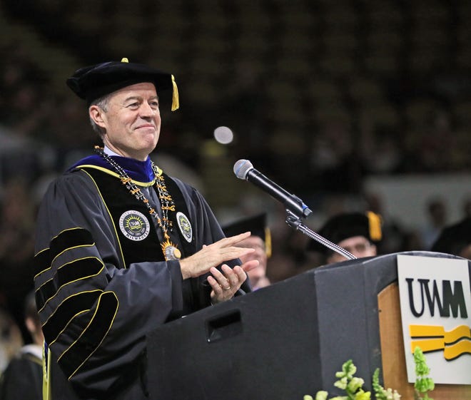 UW-Milwaukee Chancellor Mark Mone applauds the graduates during his remarks.