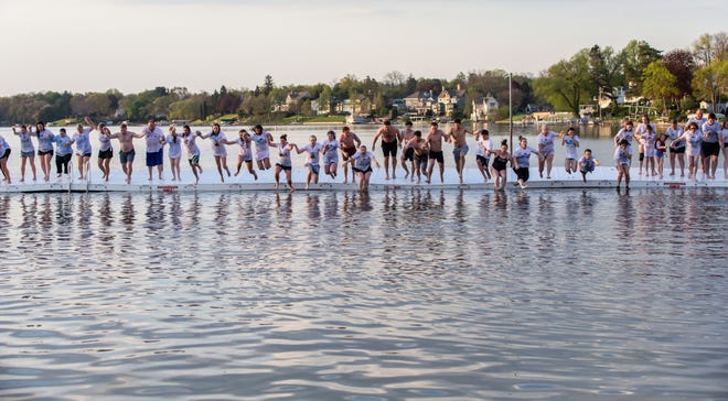 More than fifty people who have lost family or friends to the overdose epidemic take part in the final jump during the 5th Annual Jump for Archie Concert and Training at Oconomowoc City Beach on Wednesday, May 15, 2019. The Jump for Archie is hosted by Saving Others for Archie (SOFA) Inc.