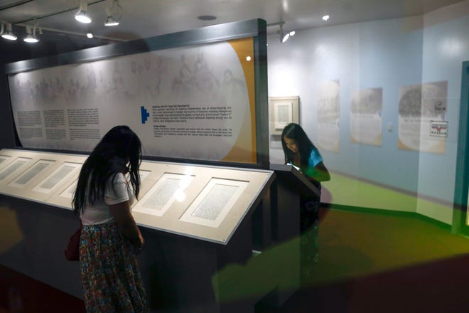 Members of the media inspect the pages of the Navajo-U.S. Treaty of 1868 on June 1, 2018 at the Navajo Nation Museum in Window Rock, Arizona.
