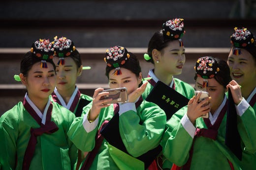 TOPSHOT - Participants pose for selfies as they attend a traditional Coming-of-Age Day ceremony to mark adulthood at Namsan hanok village in Seoul on May 20, 2019. - The ceremony marks the age of 19, at which a person is legally able to make life choices from voting, to drinking alcohol. (Photo by Ed JONES / AFP)ED JONES/AFP/Getty Images ORIG FILE ID: AFP_1GO45V